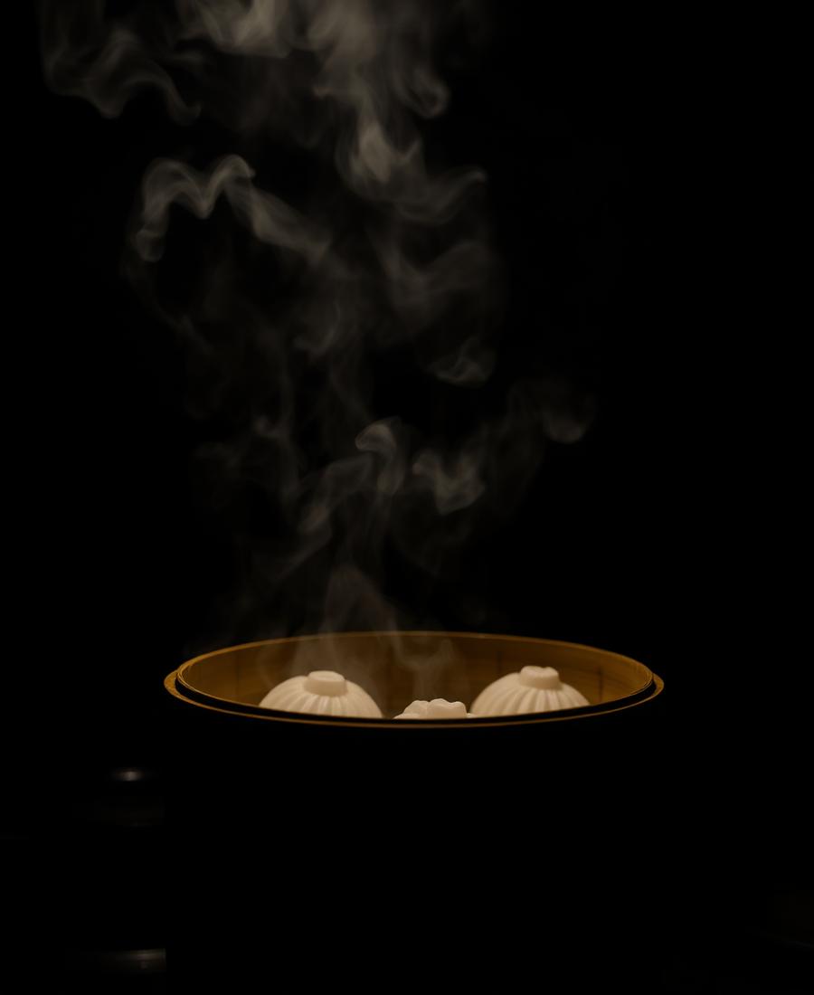 Steam rising from a bamboo steamer basket